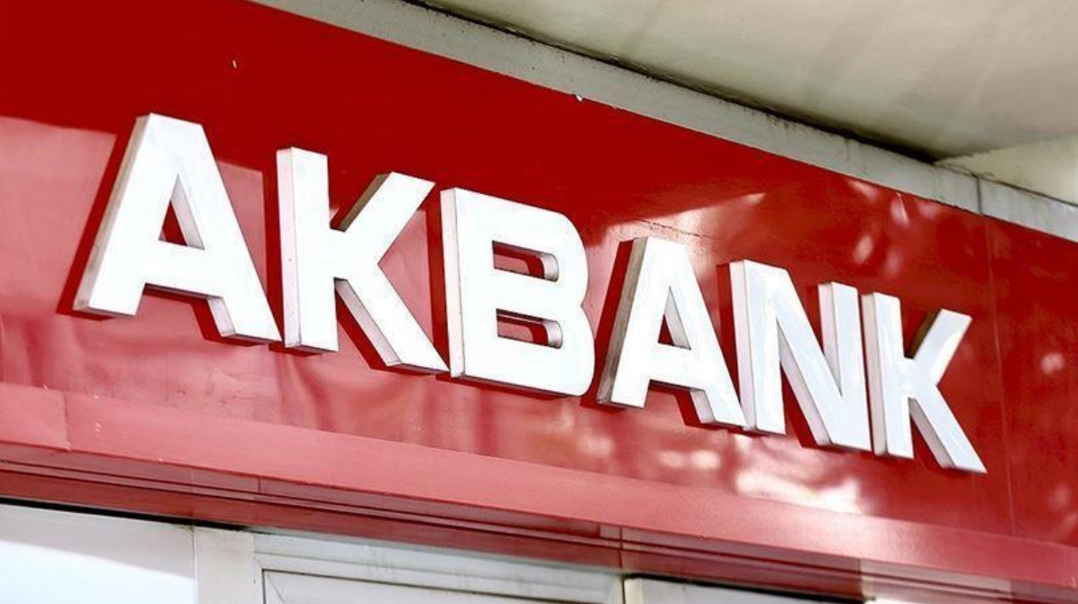 Akbank şubesinin kırmızı tabela üzerinde yer alan beyaz Akbank logosu, taşıt kredisi ve bankacılık hizmetlerinde kurumsal kimliği vurguluyor.