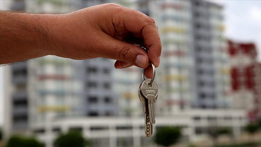  Çok katlı apartmanların önünde tutulan anahtar, Emlak Konut kampanyasındaki avantajlı ödeme seçeneklerini vurguluyor.