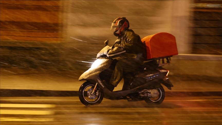 kötü hava koşullarında motor süren bir kurye