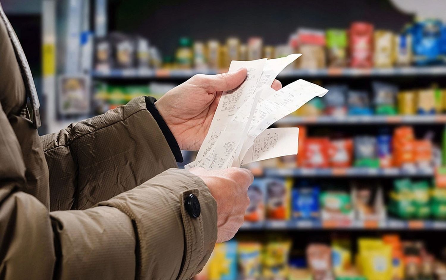 Bir tüketicinin market alışveriş fişlerini inceleyerek enflasyon ve fiyat artışlarını takip etmesi.