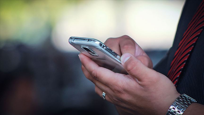 Deprem sonrası bilgi almak için telefonunu kullanan bir adam. Acil durum iletişimi için kısa mesaj uygulaması kullanıyor.